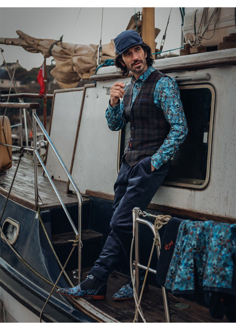 A Fish Named Fred Tartan Wool Gilet Navy - Lifestyle: model op een zeilboot, met navy geruit gilet.